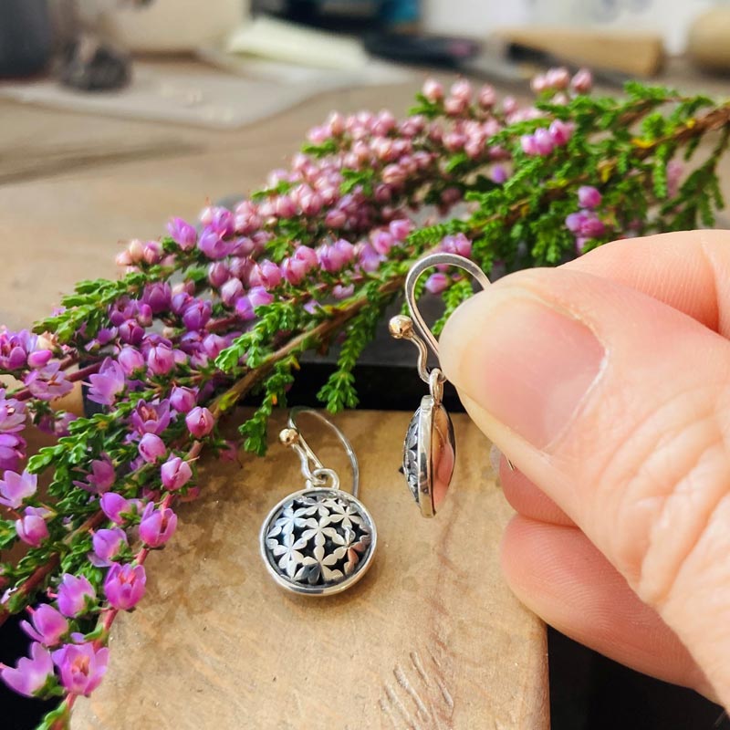 Flower drop sterling silver earrings on jewellery workbench